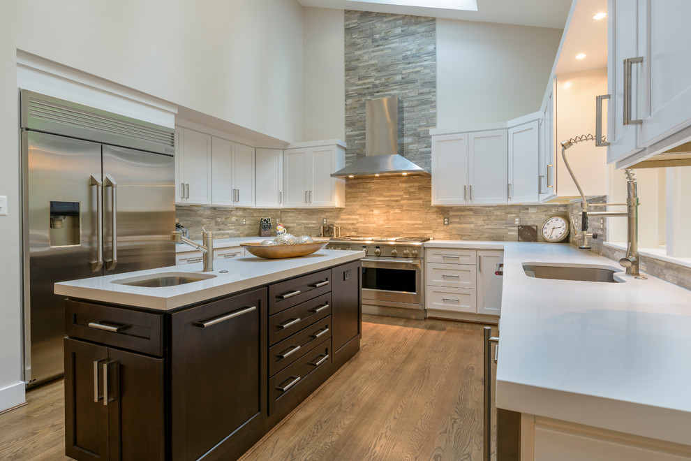 Large transitional u-shaped medium tone wood floor kitchen pantry photo in DC Metro with an undermount sink, shaker cabinets, white cabinets, quartz countertops, multicolored backsplash, slate backsplash, stainless steel appliances and two islands