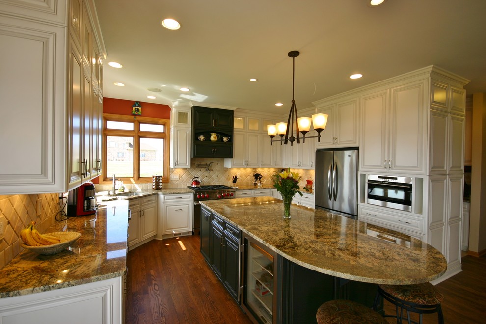 Exempel på ett mellanstort modernt kök, med en dubbel diskho, luckor med upphöjd panel, vita skåp, granitbänkskiva, beige stänkskydd, stänkskydd i stenkakel, rostfria vitvaror, mellanmörkt trägolv och en köksö