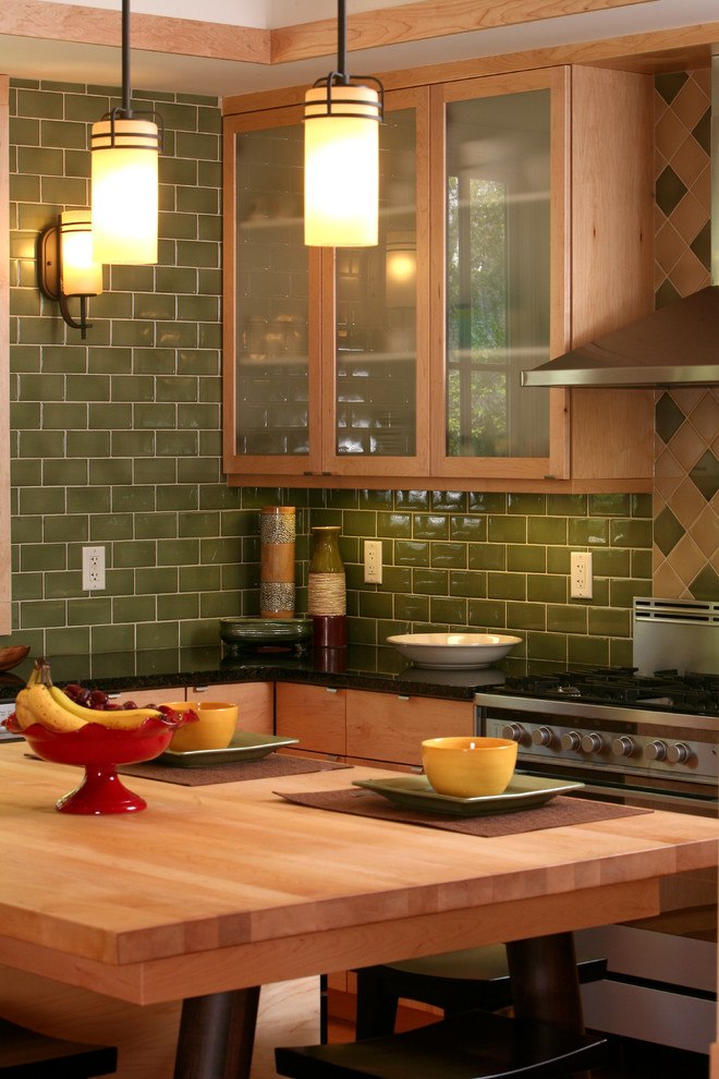 Modern inredning av ett stort kök, med släta luckor, skåp i ljust trä, granitbänkskiva, grönt stänkskydd, stänkskydd i keramik, rostfria vitvaror, mellanmörkt trägolv, en köksö och en undermonterad diskho