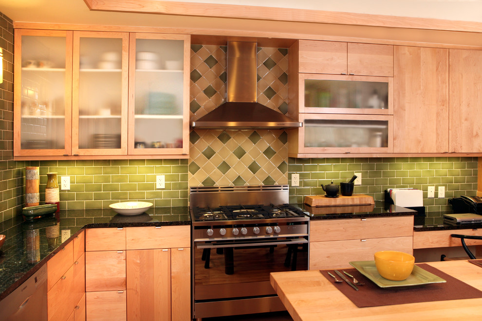 Exempel på ett modernt kök, med släta luckor, skåp i ljust trä, granitbänkskiva, grönt stänkskydd, stänkskydd i keramik, rostfria vitvaror, en undermonterad diskho, mellanmörkt trägolv och en köksö
