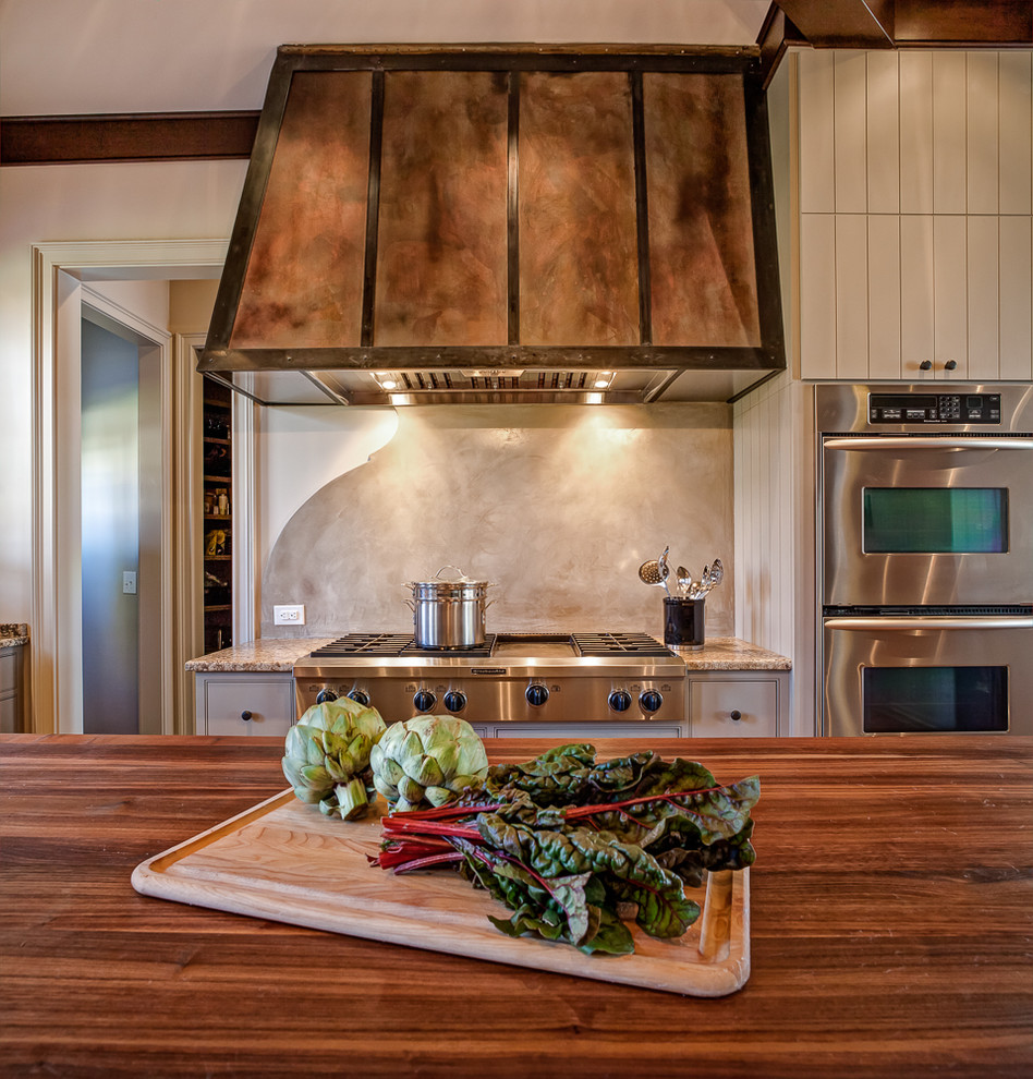 Große Mediterrane Küche in U-Form mit Küchengeräten aus Edelstahl, braunem Holzboden und zwei Kücheninseln in Charlotte