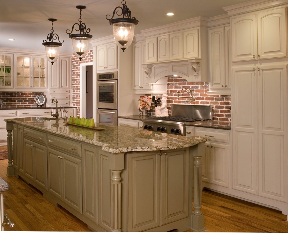 Foto på ett avskilt, mellanstort vintage u-kök, med en undermonterad diskho, luckor med upphöjd panel, vita skåp, granitbänkskiva, rött stänkskydd, stänkskydd i stenkakel, rostfria vitvaror, ljust trägolv, en köksö och brunt golv