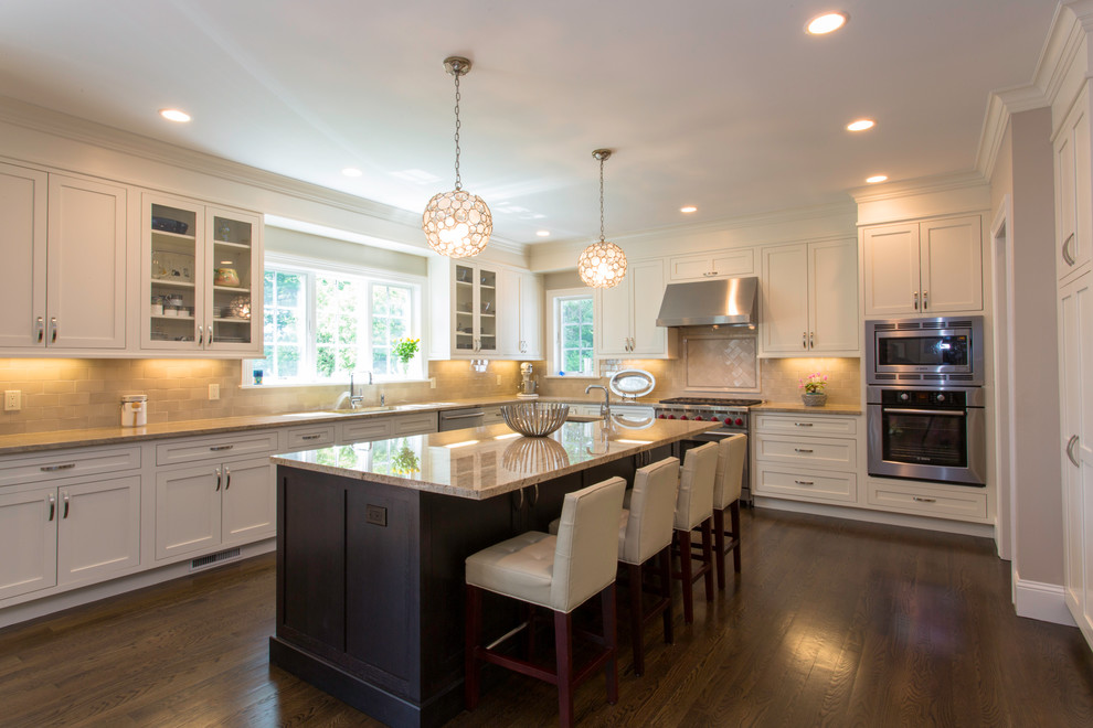 Large transitional l-shaped dark wood floor and brown floor eat-in kitchen photo in New York with an undermount sink, shaker cabinets, white cabinets, granite countertops, stone tile backsplash, stainless steel appliances, an island and beige backsplash