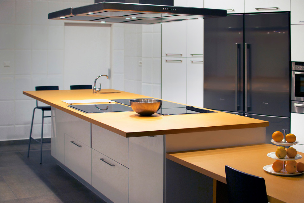 Idéer för att renovera ett mellanstort funkis orange oranget kök och matrum, med en integrerad diskho, släta luckor, vita skåp, klinkergolv i porslin och en köksö