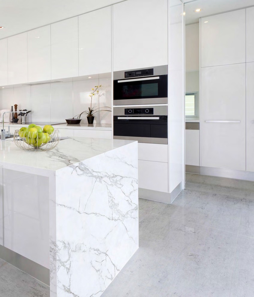 Photo of a medium sized modern kitchen in Atlanta with flat-panel cabinets, white cabinets, porcelain flooring and an island.