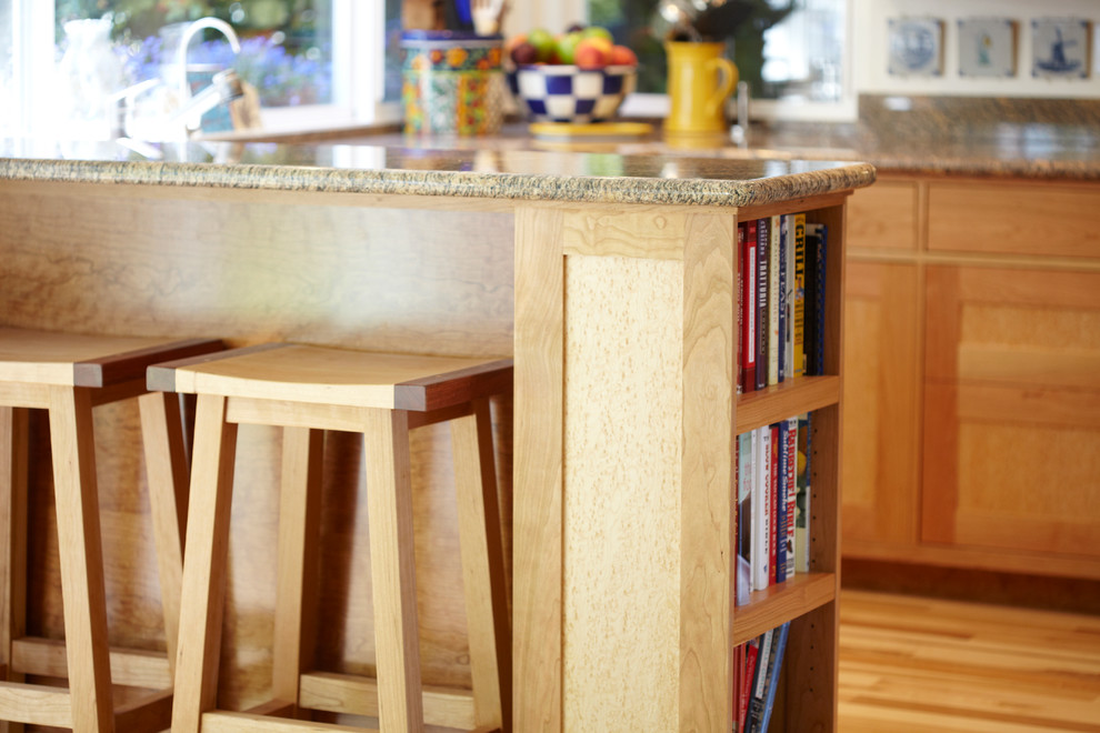 Exemple d'une cuisine ouverte tendance en U et bois brun avec un évier encastré, un placard à porte shaker, un plan de travail en granite et un électroménager en acier inoxydable.