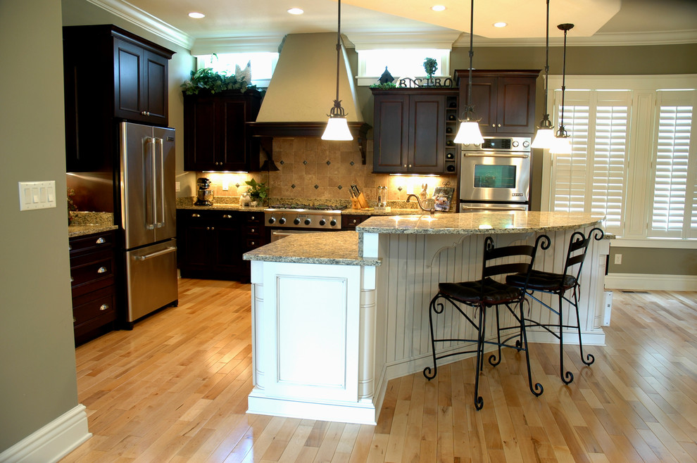 Inspiration for a timeless l-shaped kitchen remodel in Indianapolis with recessed-panel cabinets, dark wood cabinets, granite countertops and stainless steel appliances
