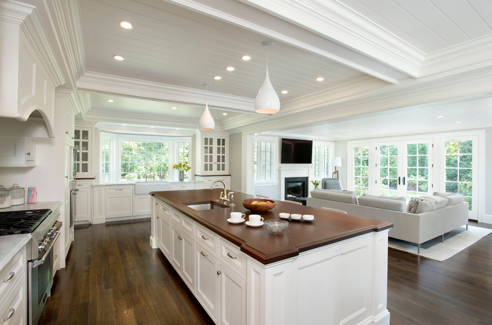 Immagine di una grande cucina country con lavello sottopiano, ante a filo, ante bianche, top in marmo, parquet scuro e pavimento marrone
