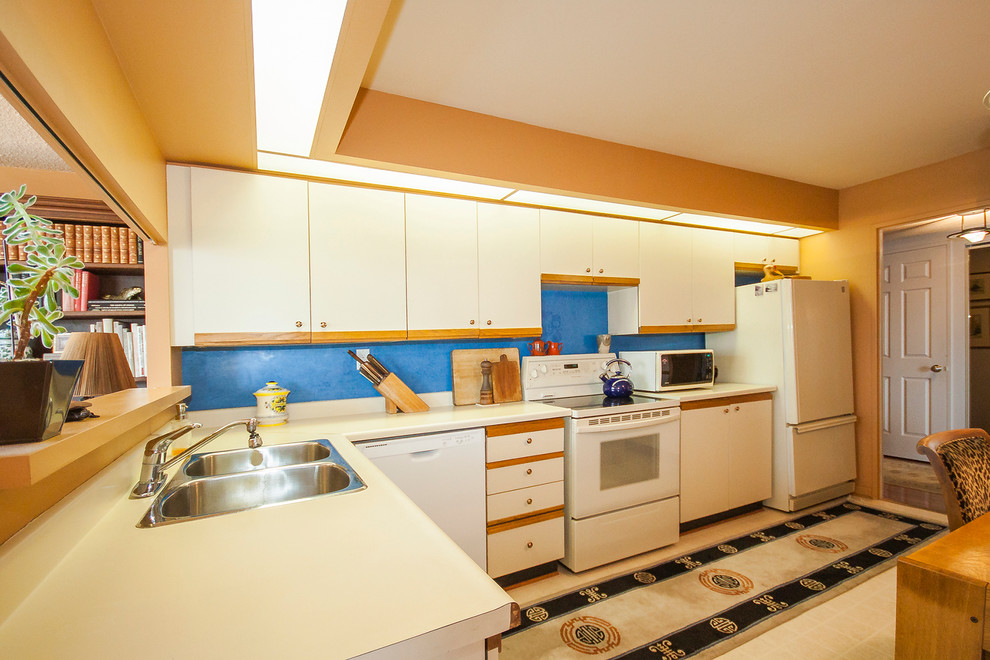 トロントにあるお手頃価格の広いエクレクティックスタイルのおしゃれなキッチン (ダブルシンク、ラミネートカウンター、青いキッチンパネル、白い調理設備、リノリウムの床、アイランドなし、フラットパネル扉のキャビネット、ベージュのキャビネット、ベージュの床、ベージュのキッチンカウンター) の写真