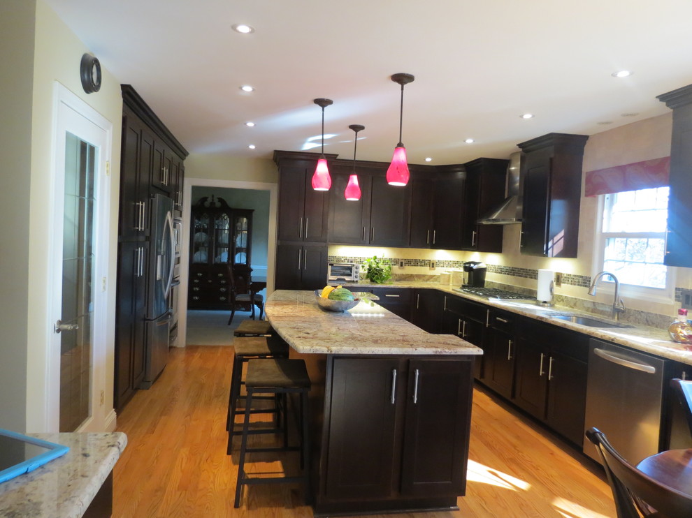 Example of a classic l-shaped eat-in kitchen design in DC Metro with granite countertops, an undermount sink, dark wood cabinets, ceramic backsplash and stainless steel appliances
