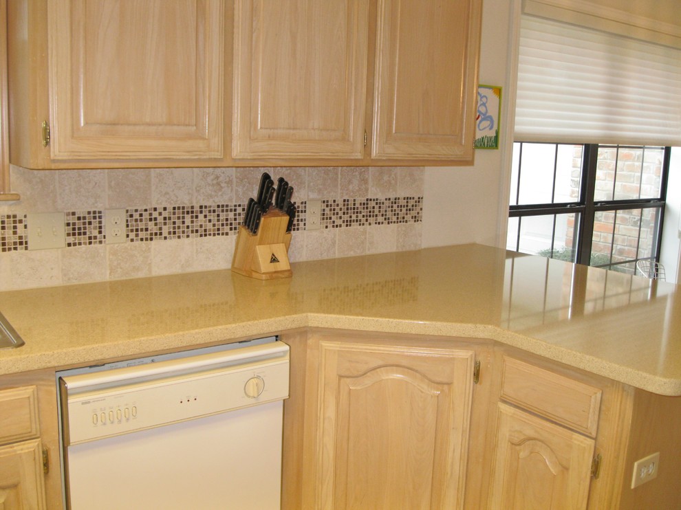 Example of a classic kitchen design in Austin with a drop-in sink, beige cabinets, beige backsplash and white appliances
