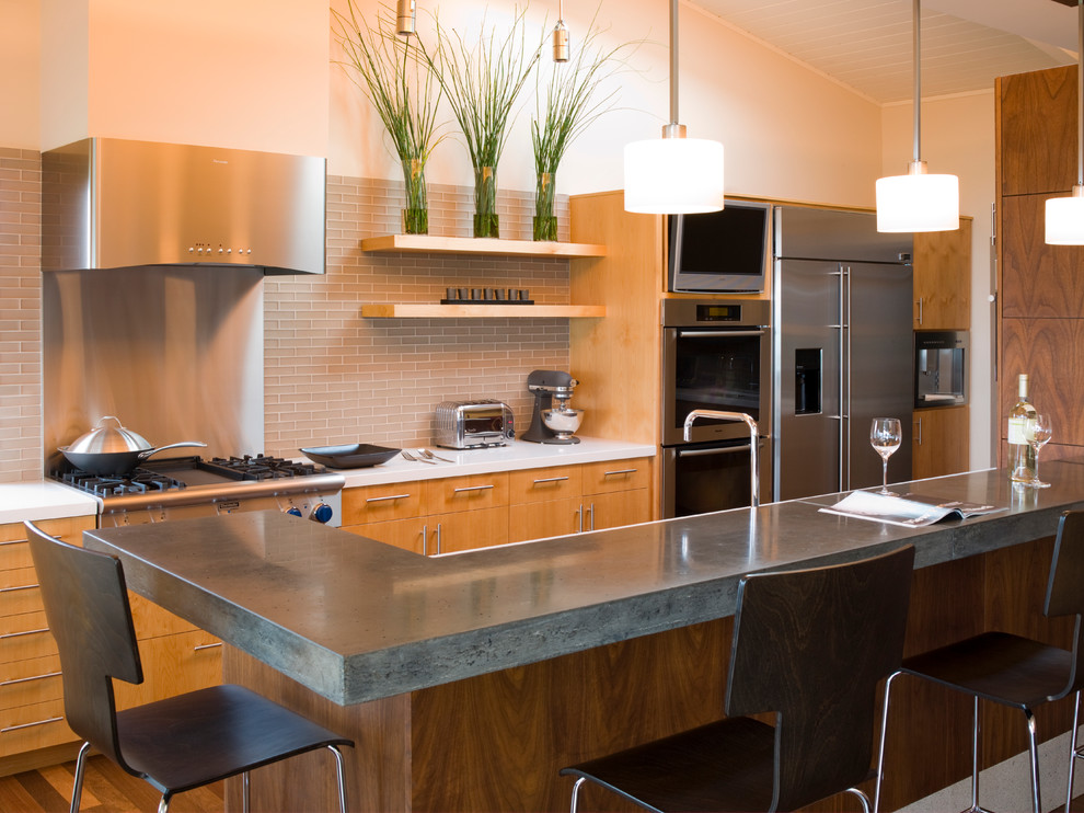 Example of a trendy kitchen design in San Francisco with stainless steel appliances, concrete countertops, flat-panel cabinets, light wood cabinets and gray backsplash