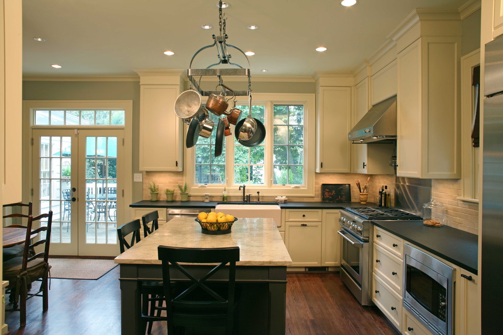 Inspiration for a large timeless l-shaped dark wood floor eat-in kitchen remodel in Charlotte with a farmhouse sink, white cabinets, granite countertops, beige backsplash, ceramic backsplash, stainless steel appliances, an island and recessed-panel cabinets