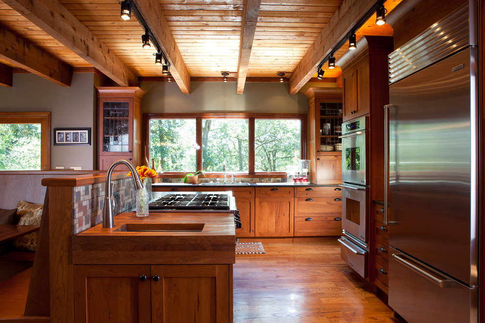 アトランタにある小さなラスティックスタイルのおしゃれなキッチン (シェーカースタイル扉のキャビネット、中間色木目調キャビネット、モザイクタイルのキッチンパネル、シルバーの調理設備、無垢フローリング) の写真