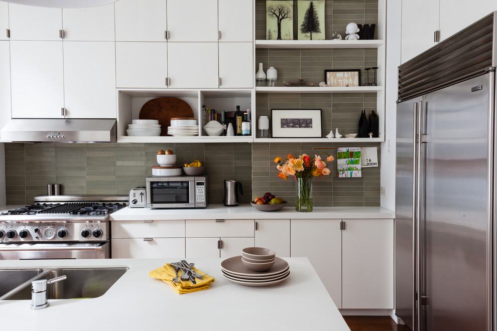 Photo of a large traditional u-shaped open plan kitchen in San Francisco with a double-bowl sink, flat-panel cabinets, white cabinets, engineered stone countertops, beige splashback, glass tiled splashback, stainless steel appliances and an island.