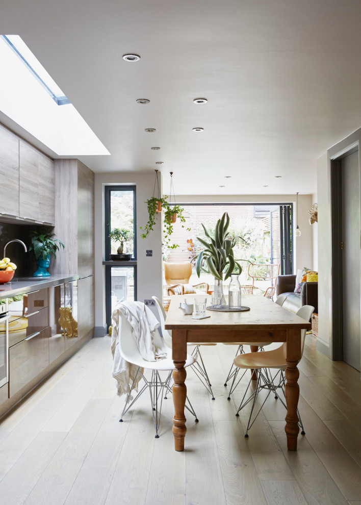 Свежая идея для дизайна: прямая кухня-гостиная в современном стиле с монолитной мойкой, техникой под мебельный фасад и светлым паркетным полом без острова - отличное фото интерьера