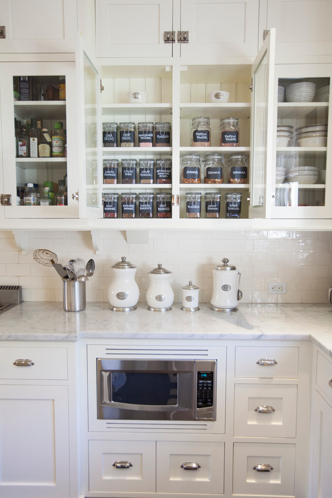 This is an example of a traditional kitchen in San Diego with white cabinets, white splashback, metro tiled splashback and shaker cabinets.