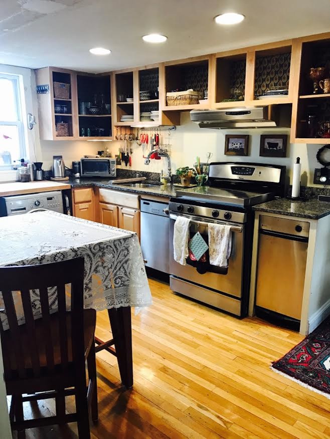 Exempel på ett mellanstort lantligt kök, med en undermonterad diskho, luckor med upphöjd panel, skåp i ljust trä, granitbänkskiva, rostfria vitvaror, ljust trägolv, en köksö och beiget golv