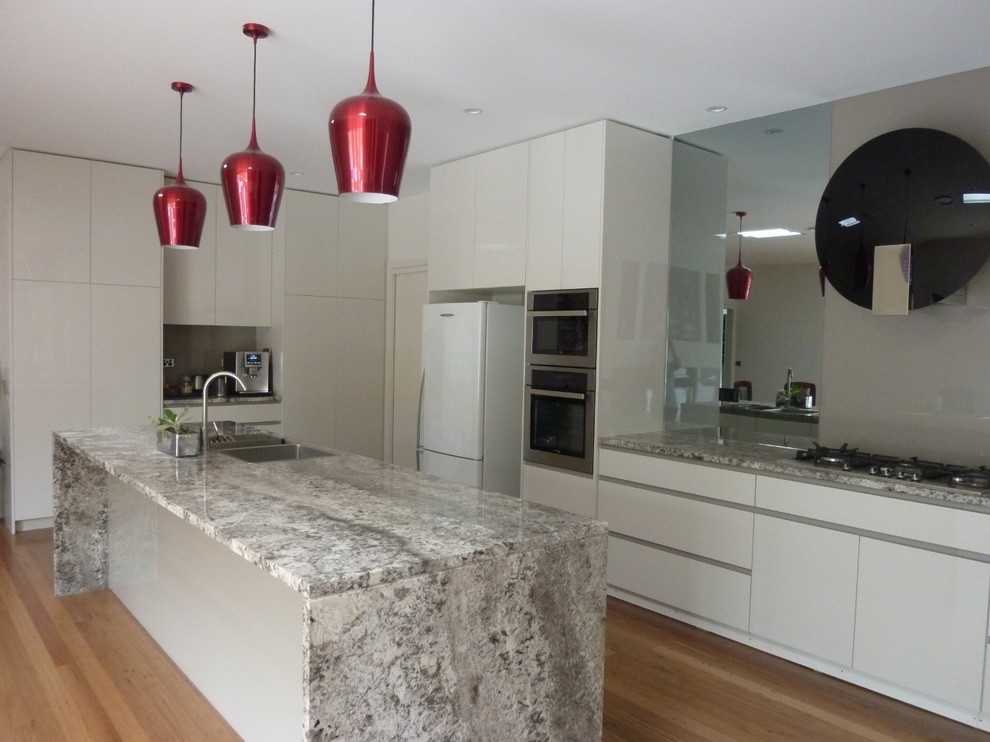 Inspiration pour une grande cuisine ouverte parallèle minimaliste avec un plan de travail en granite et îlot.