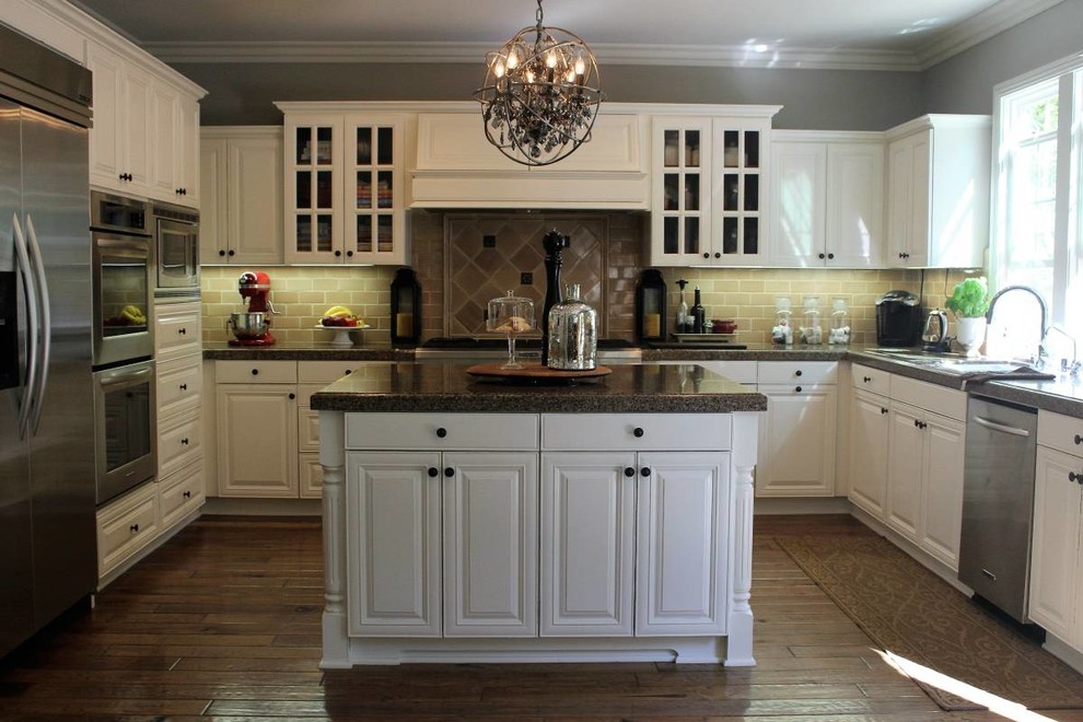 Eat-in kitchen - large traditional u-shaped light wood floor eat-in kitchen idea in Orange County with white cabinets, granite countertops, beige backsplash, porcelain backsplash, stainless steel appliances and an island
