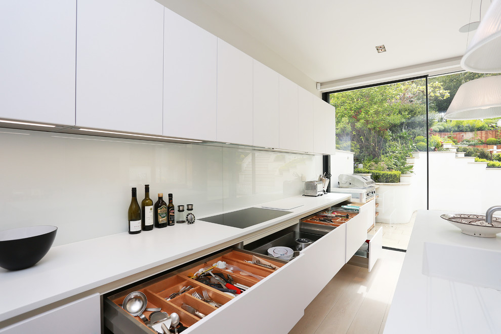 Foto de cocina moderna con puertas de armario blancas y salpicadero blanco