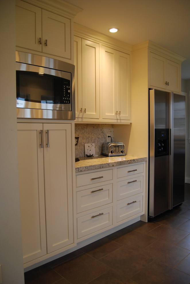 Example of a mid-sized classic galley porcelain tile and brown floor enclosed kitchen design in Boston with an undermount sink, beaded inset cabinets, beige cabinets, granite countertops, multicolored backsplash, granite backsplash, stainless steel appliances, no island and multicolored countertops