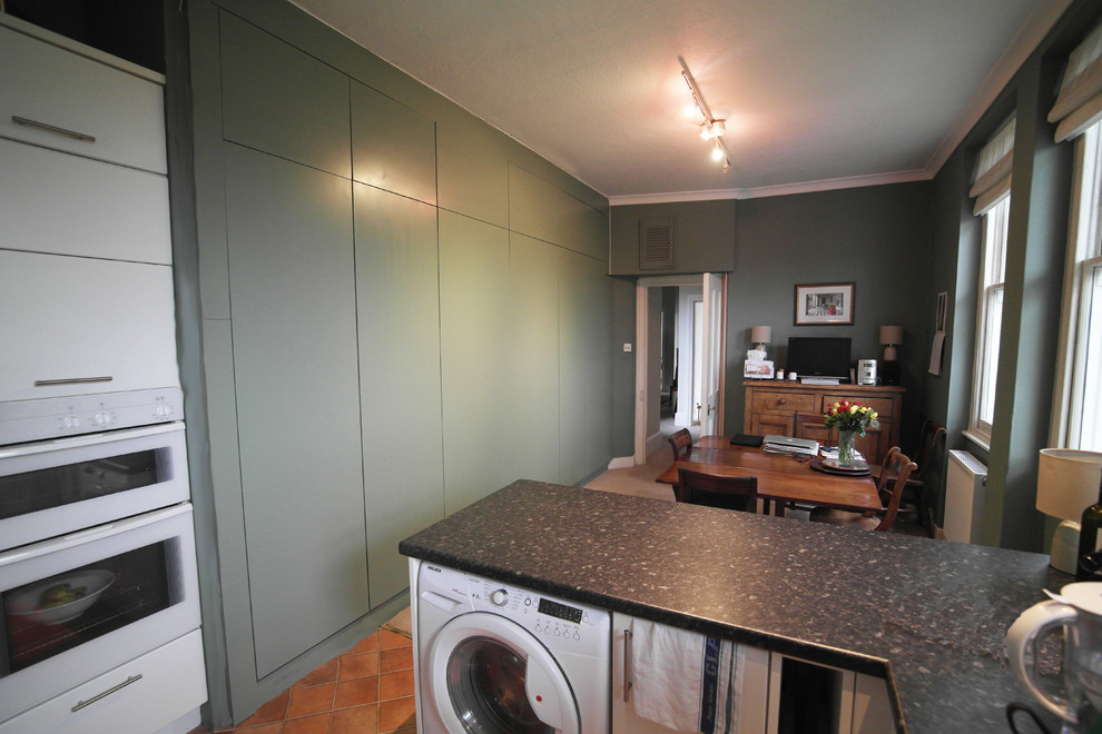 Inspiration for a large traditional single-wall kitchen pantry in London with flat-panel cabinets and green cabinets.