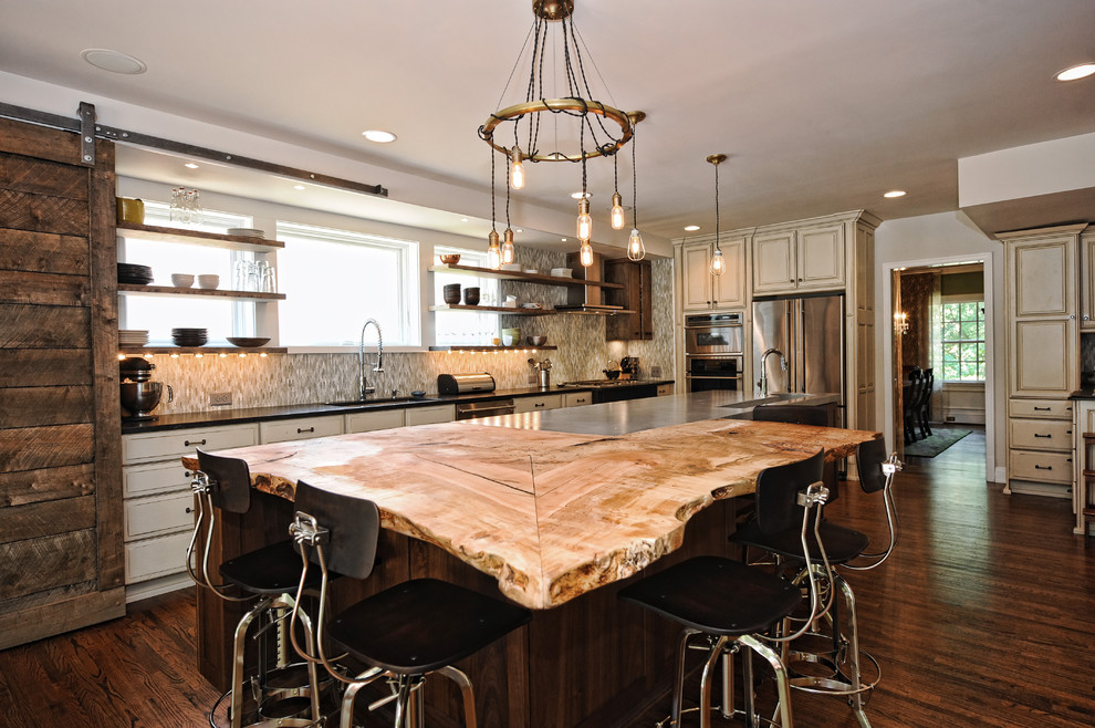 Inspiration for a rustic l-shaped dark wood floor kitchen remodel in Charlotte with beige cabinets, gray backsplash, stainless steel appliances and an island