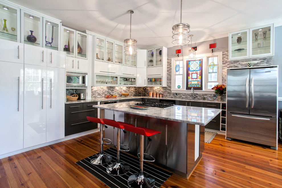 チャールストンにあるコンテンポラリースタイルのおしゃれなL型キッチン (ガラス扉のキャビネット、白いキャビネット、グレーのキッチンパネル、ボーダータイルのキッチンパネル、シルバーの調理設備) の写真