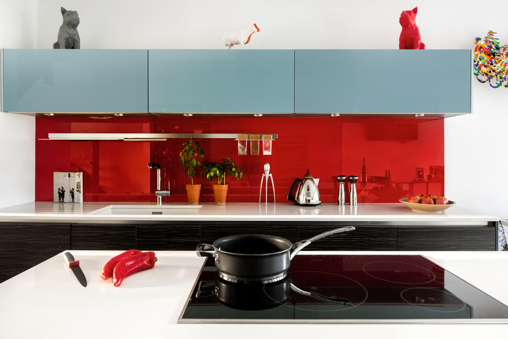 Mittelgroße Moderne Küche mit flächenbündigen Schrankfronten, türkisfarbenen Schränken, Küchenrückwand in Rot, Keramikboden, Kücheninsel und grauem Boden