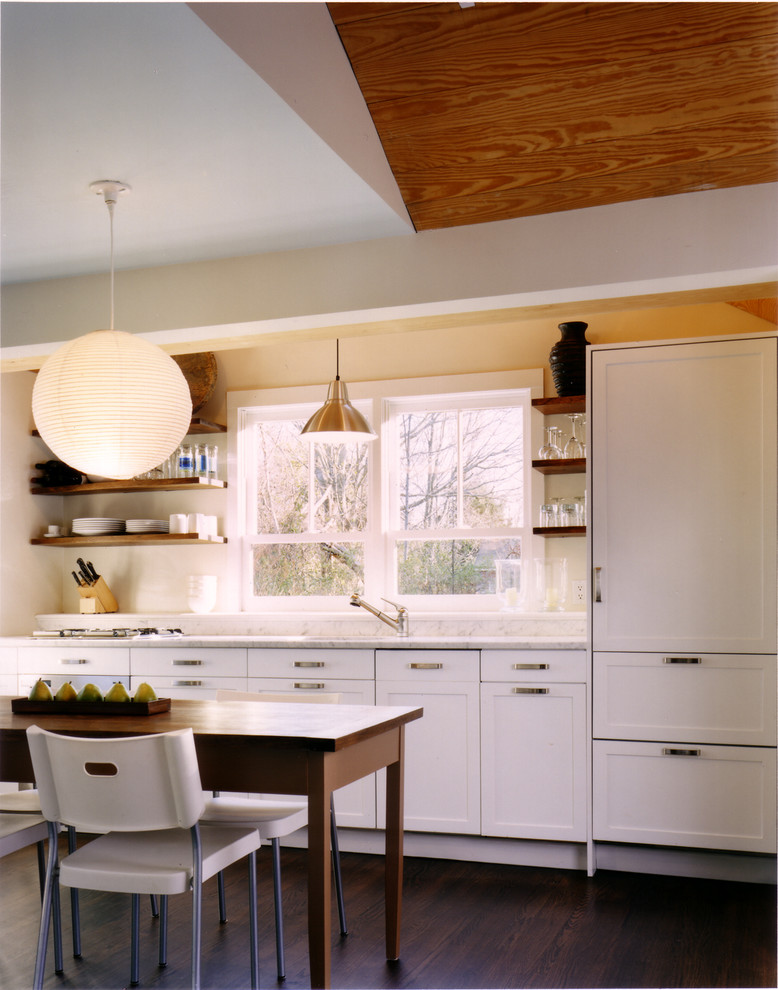 Cette image montre une cuisine chalet avec un placard avec porte à panneau encastré et des portes de placard blanches.
