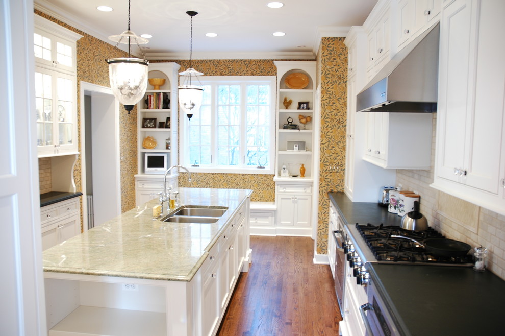 Inspiration for a large timeless u-shaped medium tone wood floor enclosed kitchen remodel in Chicago with beaded inset cabinets, white cabinets, marble countertops, beige backsplash, porcelain backsplash, paneled appliances, an undermount sink and an island