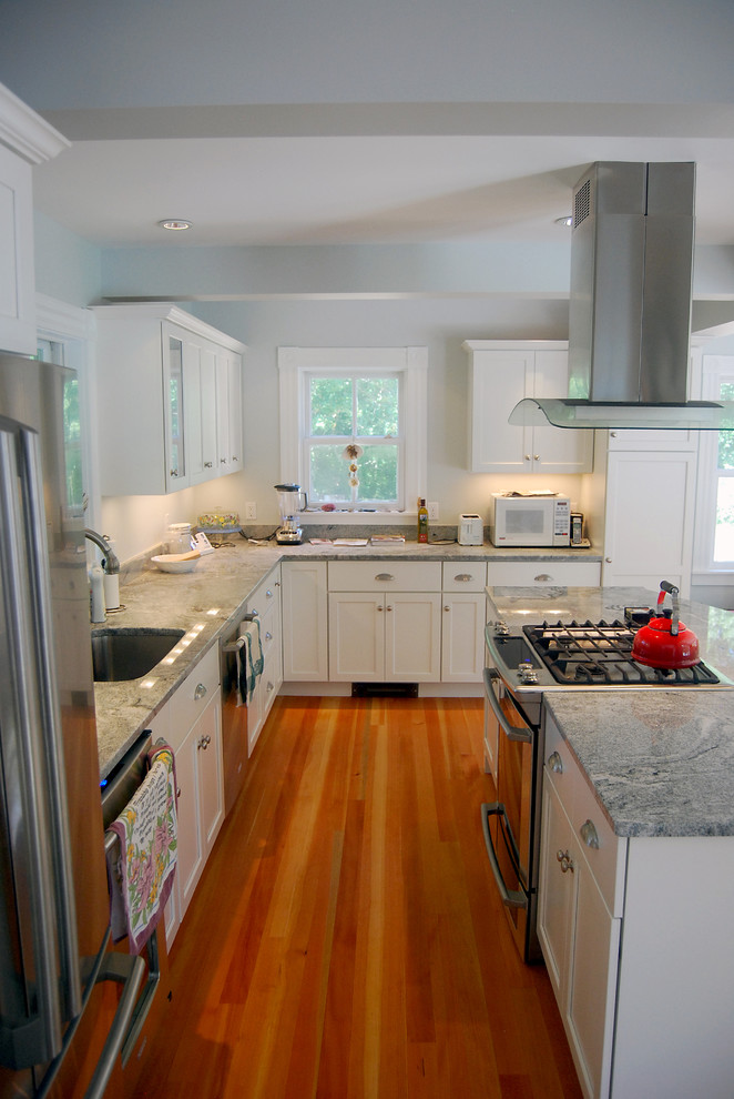 Große Klassische Küche in L-Form mit Küchengeräten aus Edelstahl, Schrankfronten im Shaker-Stil, weißen Schränken, Kücheninsel, Unterbauwaschbecken und braunem Holzboden in Boston