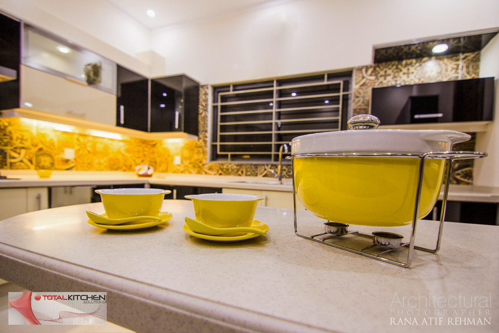 Immagine di una cucina minimal chiusa e di medie dimensioni con lavello a doppia vasca, ante lisce, ante nere, top in laminato, paraspruzzi giallo, paraspruzzi con piastrelle in ceramica, elettrodomestici neri e pavimento con piastrelle in ceramica