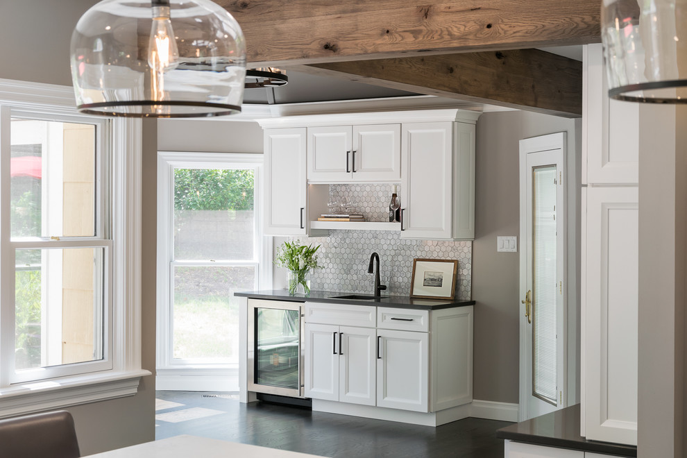 Cette photo montre une cuisine chic avec un placard avec porte à panneau encastré, des portes de placard blanches et un plan de travail en quartz modifié.