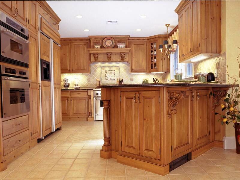 Eat-in kitchen - large traditional u-shaped ceramic tile and beige floor eat-in kitchen idea in New York with a double-bowl sink, raised-panel cabinets, medium tone wood cabinets, beige backsplash, ceramic backsplash, paneled appliances, a peninsula and black countertops
