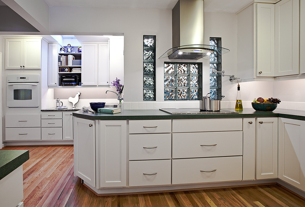 Ejemplo de cocina comedor actual con armarios con paneles lisos, puertas de armario blancas, salpicadero blanco y electrodomésticos de acero inoxidable