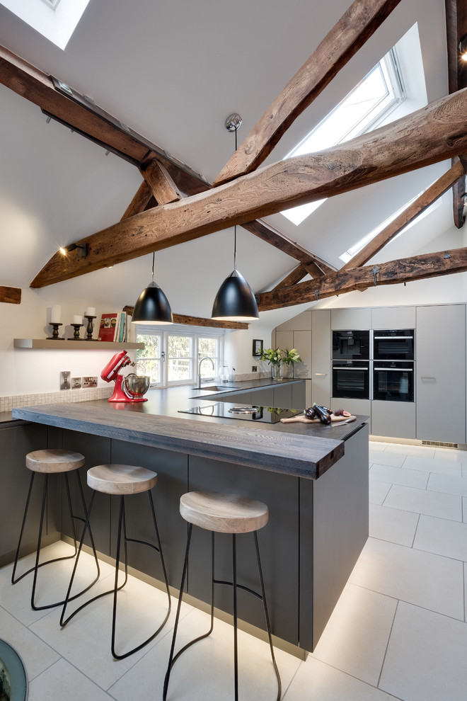 Design ideas for a medium sized classic l-shaped enclosed kitchen in Gloucestershire with a single-bowl sink, flat-panel cabinets, grey cabinets, quartz worktops, beige splashback, mosaic tiled splashback, integrated appliances and porcelain flooring.