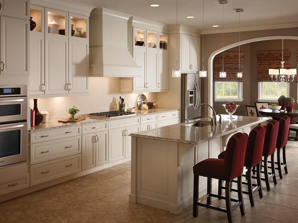 Inspiration for a mid-sized timeless single-wall ceramic tile and brown floor eat-in kitchen remodel in New York with an undermount sink, raised-panel cabinets, beige cabinets, granite countertops, beige backsplash, stainless steel appliances, an island and brown countertops