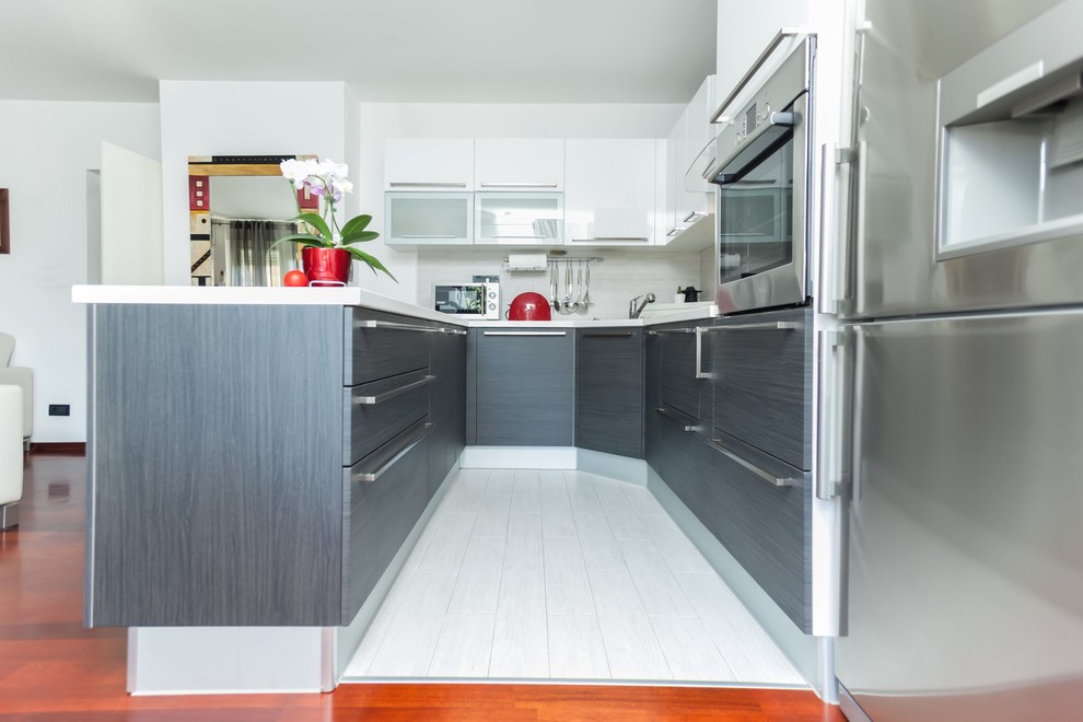 Inspiration for a mid-sized contemporary u-shaped painted wood floor eat-in kitchen remodel in New York with an undermount sink, flat-panel cabinets, white cabinets, gray backsplash, subway tile backsplash, stainless steel appliances and a peninsula