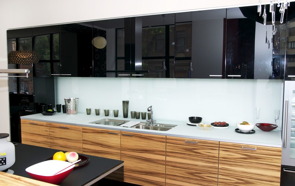 Idee per una cucina design di medie dimensioni con lavello a doppia vasca, ante lisce, ante nere, top in vetro, paraspruzzi con lastra di vetro, elettrodomestici in acciaio inossidabile e parquet scuro