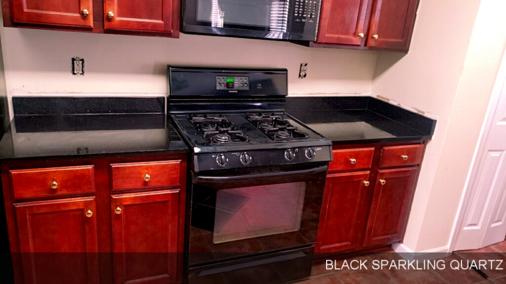 アトランタにある高級な中くらいなモダンスタイルのおしゃれなキッチン (ドロップインシンク、フラットパネル扉のキャビネット、黒いキャビネット、クオーツストーンカウンター、黒いキッチンパネル、クオーツストーンのキッチンパネル、シルバーの調理設備、大理石の床、赤い床、黒いキッチンカウンター) の写真