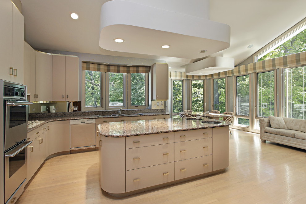 Design ideas for a large contemporary l-shaped open plan kitchen in Other with a triple-bowl sink, flat-panel cabinets, beige cabinets, granite worktops, stainless steel appliances, light hardwood flooring, an island and beige floors.