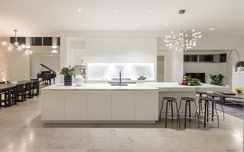 Idéer för mellanstora funkis vitt kök, med en undermonterad diskho, släta luckor, vita skåp, marmorbänkskiva, vitt stänkskydd, stänkskydd i marmor, rostfria vitvaror, travertin golv, en köksö och beiget golv