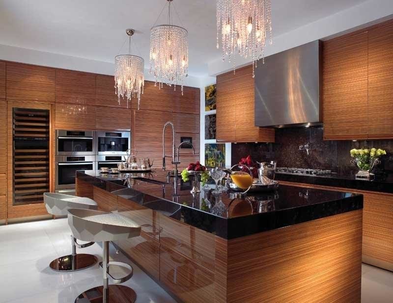 Modern inredning av ett stort kök, med en undermonterad diskho, släta luckor, skåp i mellenmörkt trä, brunt stänkskydd, stänkskydd i sten, rostfria vitvaror, en köksö och vitt golv