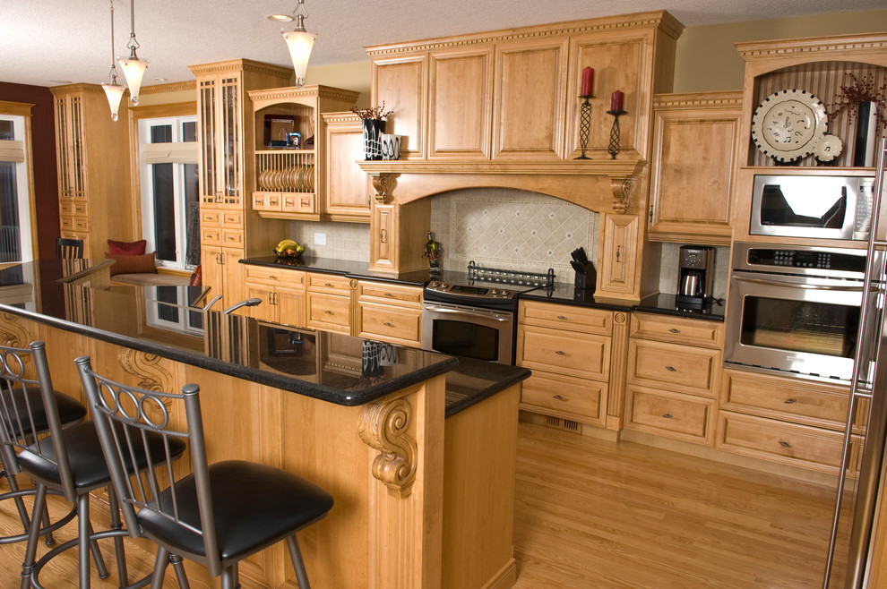 Open concept kitchen - mid-sized traditional l-shaped light wood floor open concept kitchen idea in Other with an undermount sink, raised-panel cabinets, light wood cabinets, granite countertops, beige backsplash, stainless steel appliances and an island
