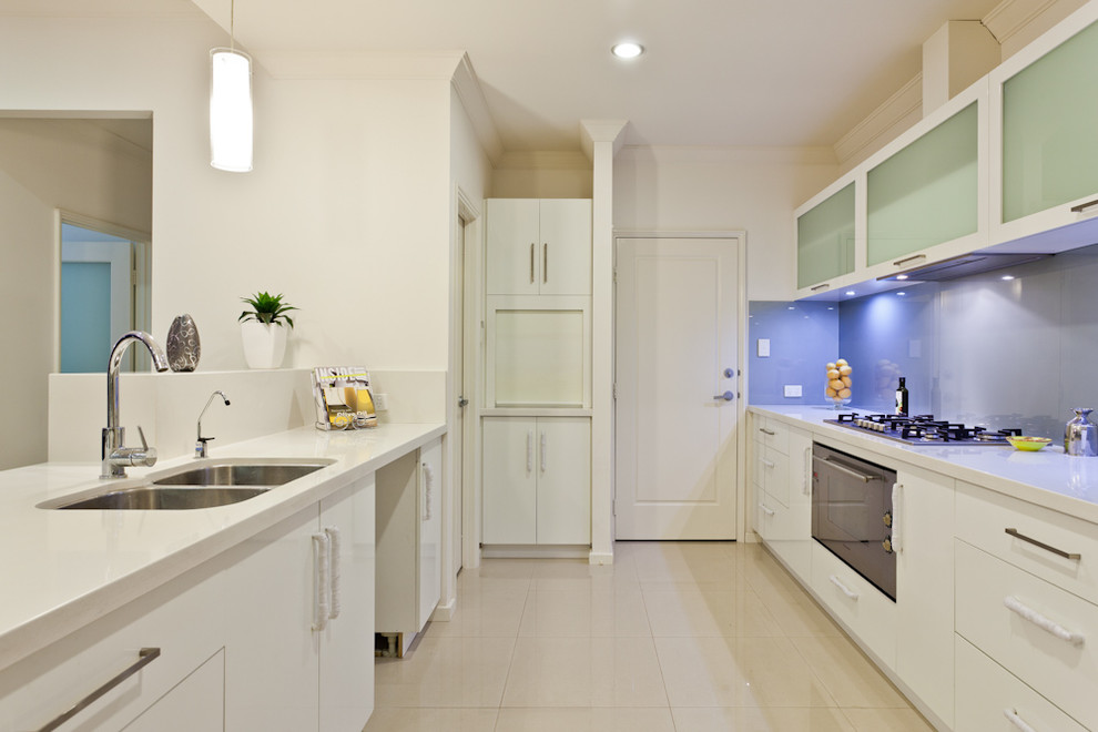 Esempio di una cucina design con lavello a doppia vasca, ante lisce, ante beige, paraspruzzi con lastra di vetro e elettrodomestici in acciaio inossidabile
