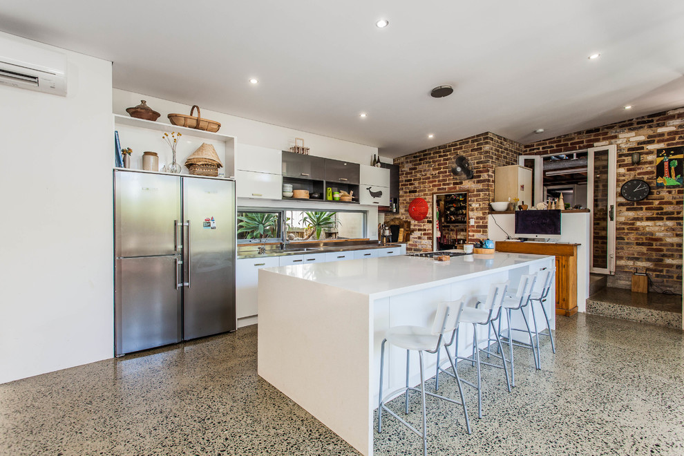 Zweizeilige, Mittelgroße Wohnküche mit flächenbündigen Schrankfronten, weißen Schränken, Küchengeräten aus Edelstahl und Kücheninsel in Perth