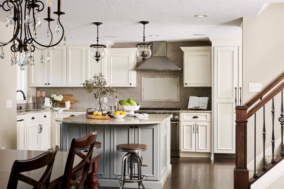 Large classic grey and cream l-shaped kitchen/diner in Minneapolis with a submerged sink, recessed-panel cabinets, white cabinets, granite worktops, grey splashback, metro tiled splashback, stainless steel appliances, dark hardwood flooring, an island, brown floors and beige worktops.