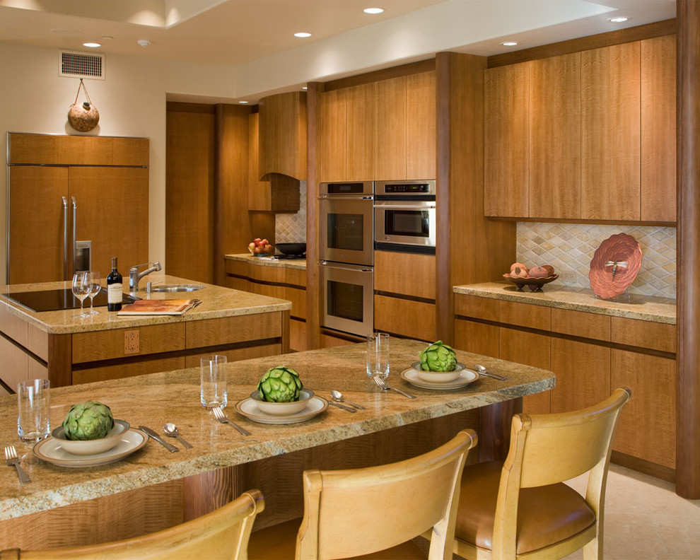 Example of a mid-sized southwest u-shaped limestone floor enclosed kitchen design in San Diego with stainless steel appliances, flat-panel cabinets, light wood cabinets, beige backsplash, granite countertops, limestone backsplash and two islands